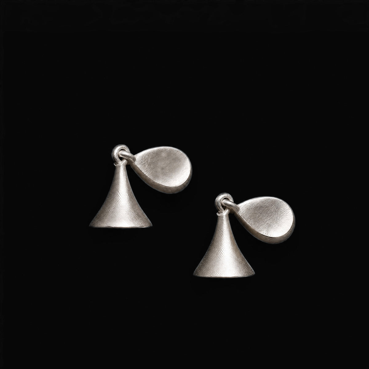Drift Bell sculptural sterling silver earrings on a black background.