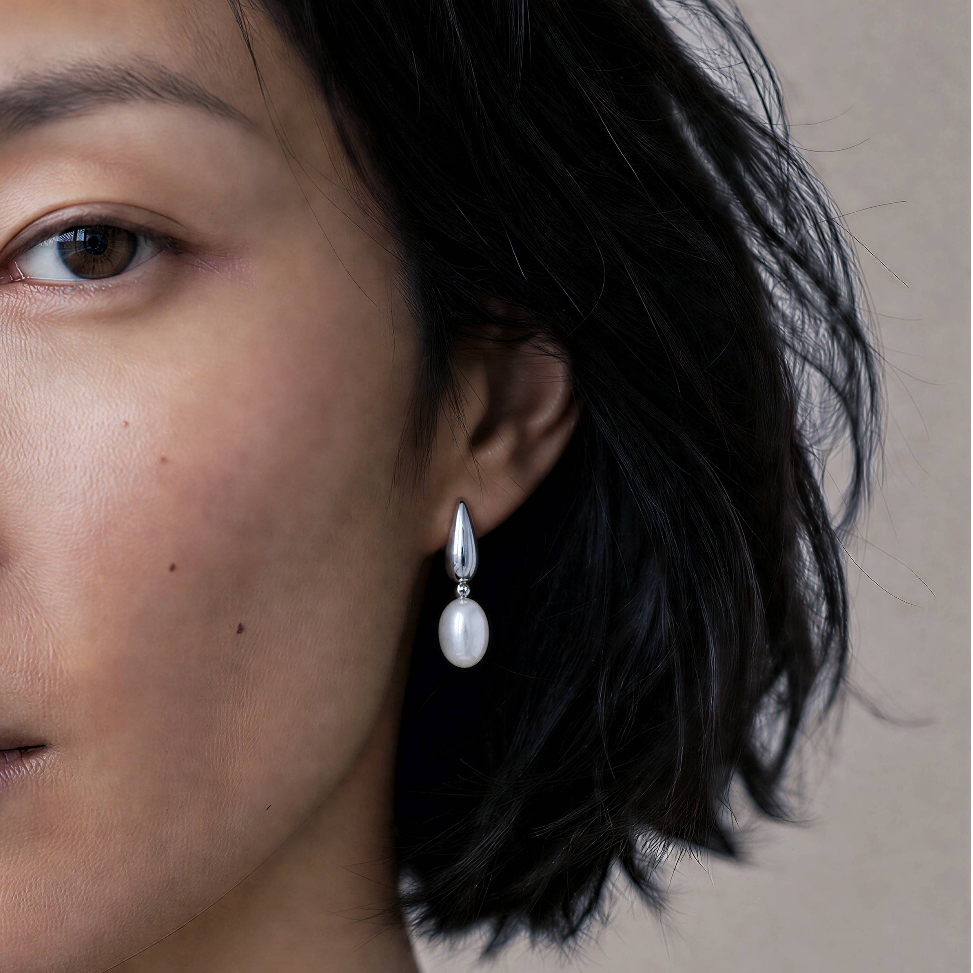 Model wearing Mist Cloud silver drop earrings with freshwater pearl details