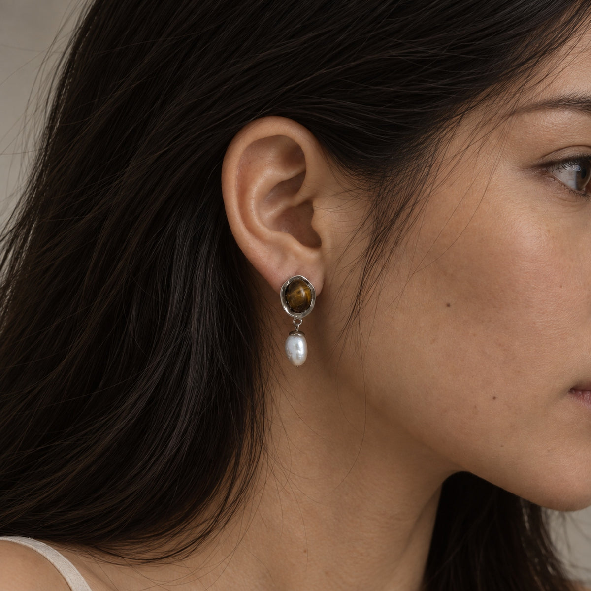 Tea Veil tiger eye and freshwater pearl earring worn on the ear