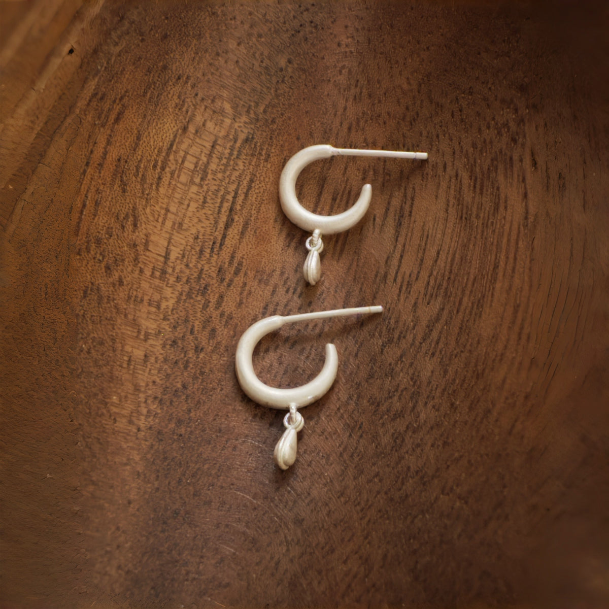 Silent Drop solid S925 sterling silver earrings on a wooden surface